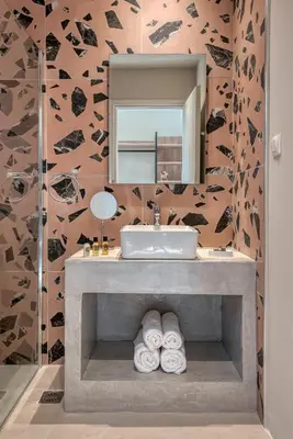 a bathroom with a sink and a mirror and towels at Saronis Suites in Saronida