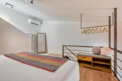 a bedroom with a bed and a table with a chair at Saronis Suites in Saronida