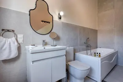 a bathroom with a sink and a toilet and a guitar on the wall at Saronis Suites in Saronida