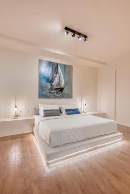 a large white bedroom with a large white bed at Saronis Suites in Saronida