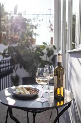a table with a bottle of wine and two glasses at Mythodea Athens Suites in Athens