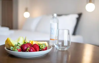 a bowl of fruit on a table next to a glass at Mythodea Athens Suites in Athens