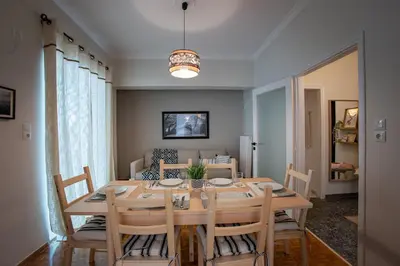 a dining room with a wooden table and chairs at The House of Praxithea for 6 by Filos Inc in Athens
