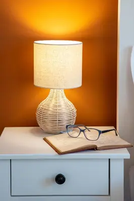 a lamp on a table with a book and glasses at The House of Praxithea for 6 by Filos Inc in Athens