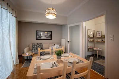 a dining room and living room with a table and chairs at The House of Praxithea for 6 by Filos Inc in Athens