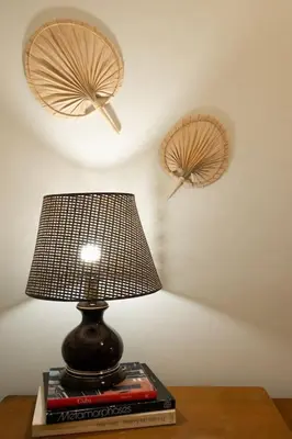 a lamp sitting on top of a book on a table at The House of Praxithea for 6 by Filos Inc in Athens