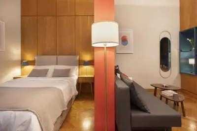 a bedroom with a bed and a chair and a lamp at Vibrant apartment in Kolonaki area in Athens