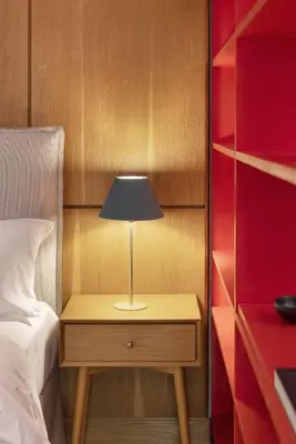 a lamp on a night stand next to a bed at Vibrant apartment in Kolonaki area in Athens
