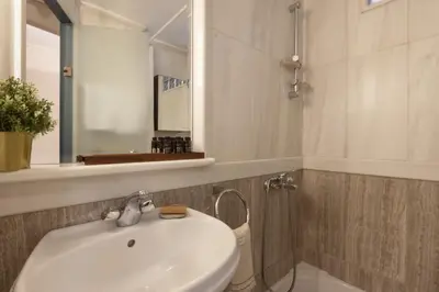 a bathroom with a white sink and a mirror at Vibrant apartment in Kolonaki area in Athens