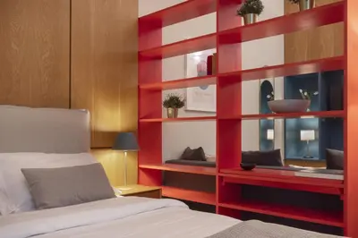a bedroom with a red shelf next to a bed at Vibrant apartment in Kolonaki area in Athens
