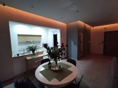a living room with a table and a kitchen at Live Minimal in Athens