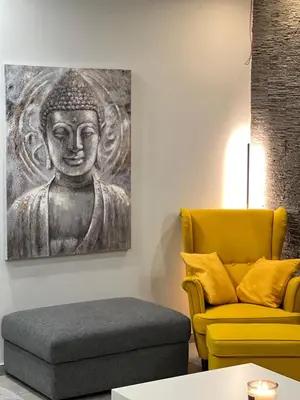 a living room with a chair and a painting of a buddha at Live Minimal in Athens