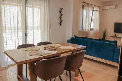 a dining room table with chairs and a blue couch at Cleo in Spáta