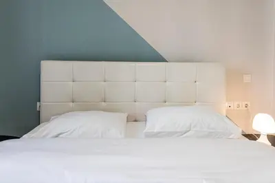a bedroom with a large white bed with two pillows at Athenian boutique apartments in Athens