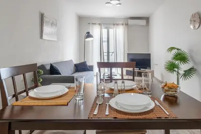 a dining room table with white plates and chairs at Athenian boutique apartments in Athens