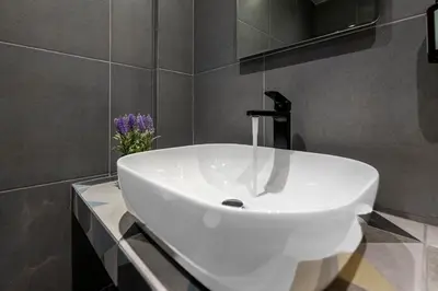 a white sink in a bathroom with a vase of flowers at Athenian boutique apartments in Athens