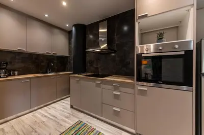 a kitchen with stainless steel appliances and wooden floors at Athenian boutique apartments in Athens
