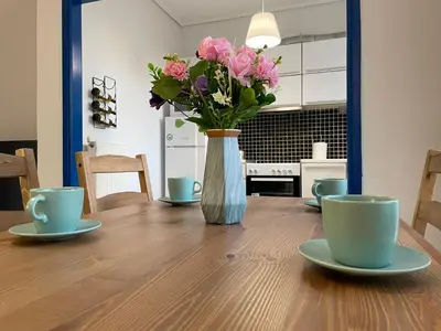 a vase of pink flowers sitting on a wooden table at Traveller's Choice Attiki in Athens