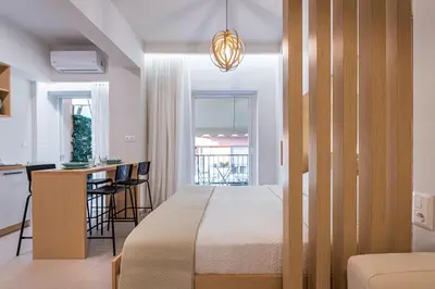 a bedroom with a bed and a kitchen with a table at Feel like home in Athens