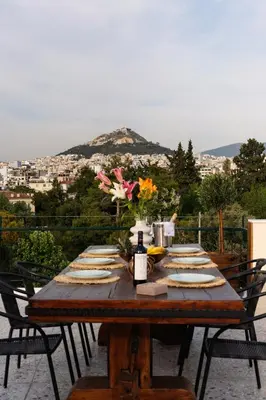 a wooden table with plates of food and a bottle of wine at Visum Acropol ,3BR - Private Terrace-Jacuzzi - Amazing View in Athens