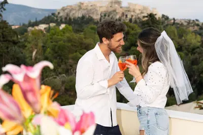 a bride and groom drinking cocktails on a balcony with a view at Visum Acropol ,3BR - Private Terrace-Jacuzzi - Amazing View in Athens