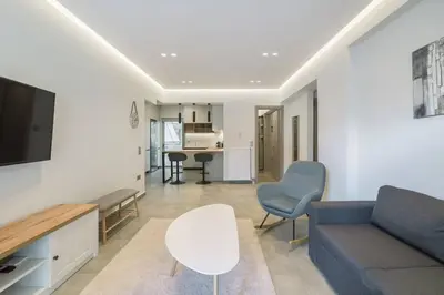 a living room with a couch and a tv at stylish zografou apartement in Athens