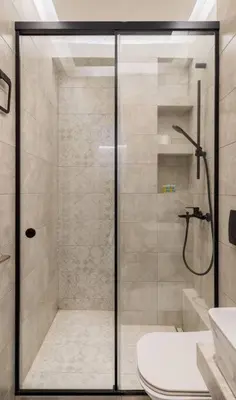a bathroom with a glass shower with a toilet at stylish zografou apartement in Athens