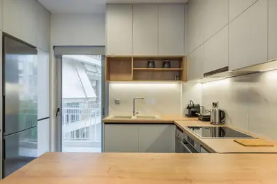 a white kitchen with a sink and a counter at stylish zografou apartement in Athens