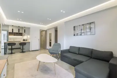a living room with a couch and a table and a kitchen at stylish zografou apartement in Athens