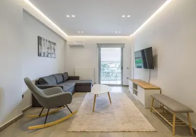 a living room with a couch and a tv at stylish zografou apartement in Athens