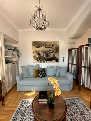 a living room with a blue couch and a table at 2 BD Apt in Syntagma with Acropolis view in Athens