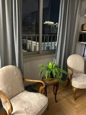 a living room with two chairs and a table and a window at 2 BD Apt in Syntagma with Acropolis view in Athens