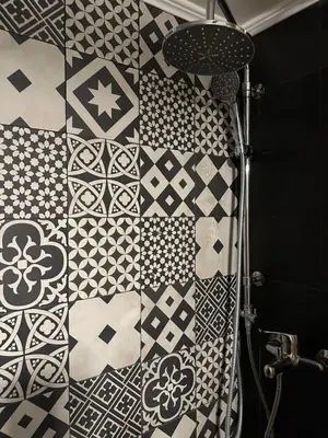 a bathroom with a wall covered in black and white tiles at 2 BD Apt in Syntagma with Acropolis view in Athens