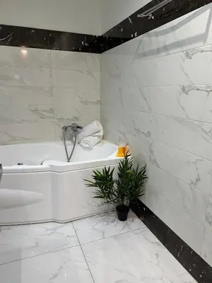 a white bathroom with a tub and a plant at 2 BD Apt in Syntagma with Acropolis view in Athens