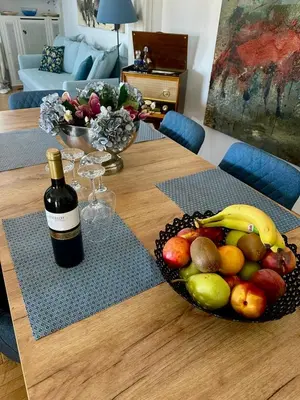 a table with a bowl of fruit and a bottle of wine at 2 BD Apt in Syntagma with Acropolis view in Athens