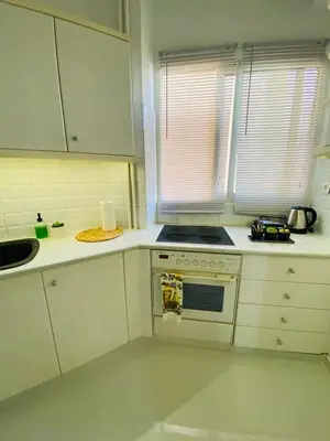a kitchen with white cabinets and a stove top oven at 2 BD Apt in Koukaki 8’ away from Acropolis in Athens