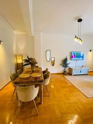 a dining room with a table and chairs and a tv at 2 BD Apt in Koukaki 8’ away from Acropolis in Athens