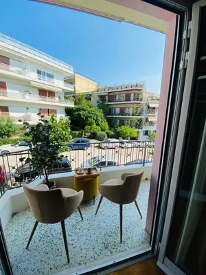 a balcony with two chairs and a view of a building at 2 BD Apt in Koukaki 8’ away from Acropolis in Athens