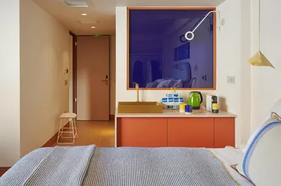 a bedroom with a bed and a kitchen with a sink at LOOM ATHENS in Athens