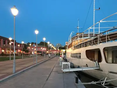 a boat is docked next to a street with lights at Athens Stylish apt next to the beach and port in Athens