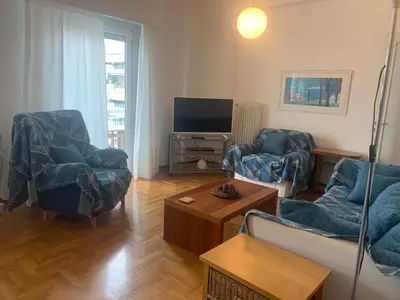 a living room with two chairs and a television at Athens Stylish apt next to the beach and port in Athens