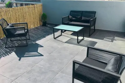 a patio with chairs and a table and a couch at Athens Riviera Modern Penthouse with Sea View in Athens