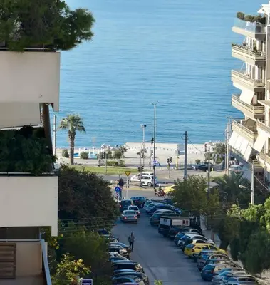 a street with cars parked next to the ocean at Athens Riviera Modern Penthouse with Sea View in Athens