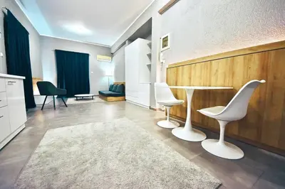 a living room with two white chairs and a table at Athens Riviera Modern Penthouse with Sea View in Athens