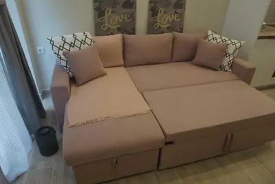a brown couch with two pillows on top of it at Vasili's and Vasiliki's luxury apartment in Athens