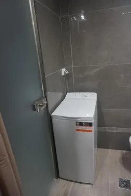 a washing machine in a bathroom next to a wall at Vasili's and Vasiliki's luxury apartment in Athens