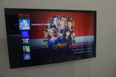 a television screen with a picture of a movie at Vasili's and Vasiliki's luxury apartment in Athens
