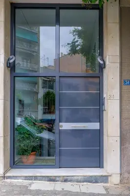 a blue door of a building with a plant at SOKOS Residence, 3' walk from Neos Kosmos Metro in Athens