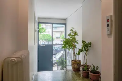 a hallway with potted plants and a blue door at SOKOS Residence, 3' walk from Neos Kosmos Metro in Athens