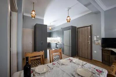 a dining room with a table and a kitchen at Danaï house in Athens
